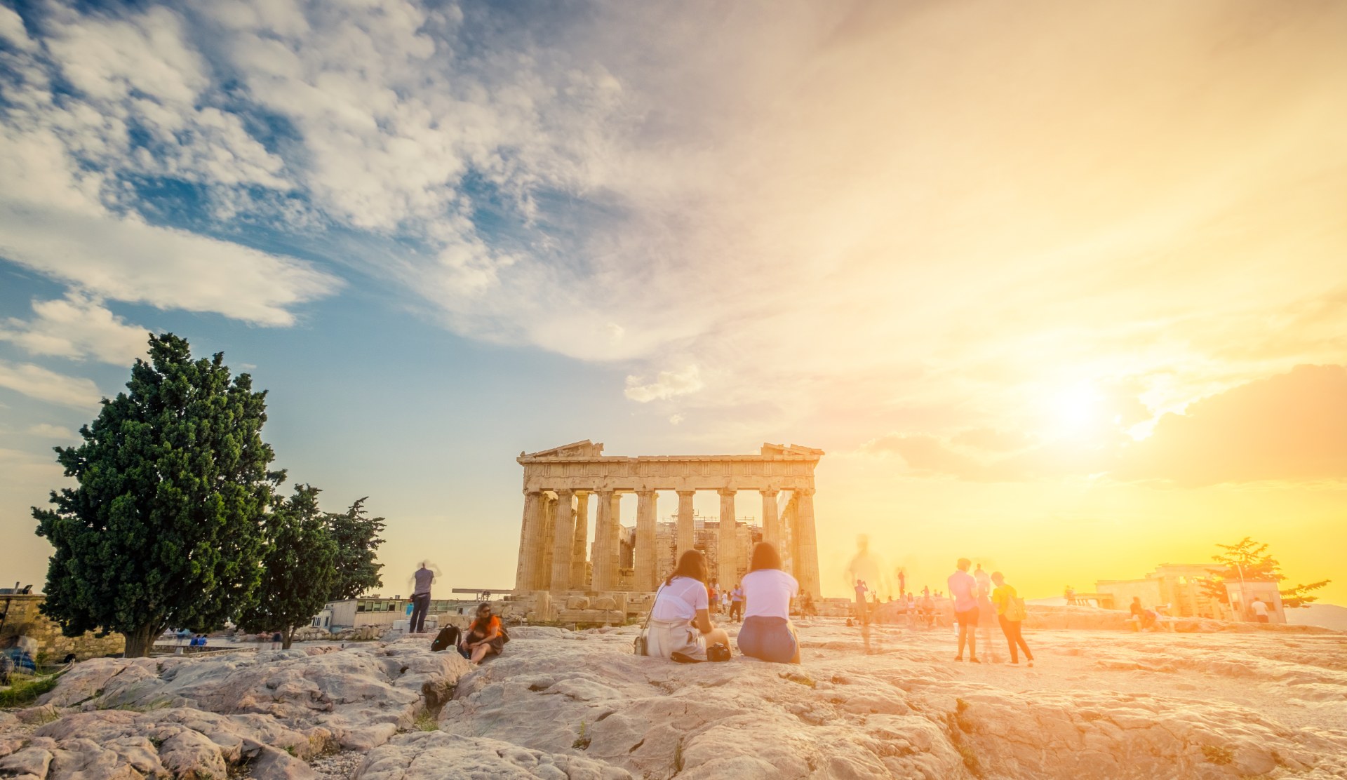 Gün batımında Akropolis’te Parthenon’un önünde oturan gençler